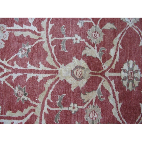 351 - Large red and pale orange ground patterned rug having a large central design surrounded by patterned... 