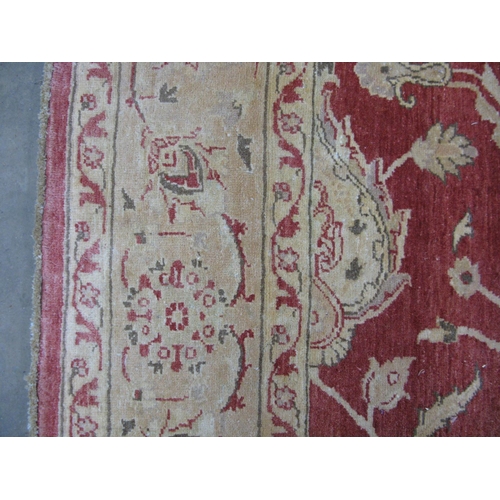 351 - Large red and pale orange ground patterned rug having a large central design surrounded by patterned... 