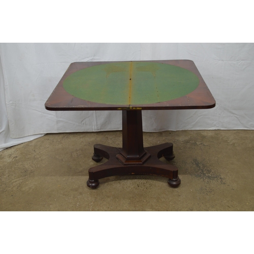 358 - Mahogany fold over card table the top opening to a circular green baize, standing on hexagonal colum... 