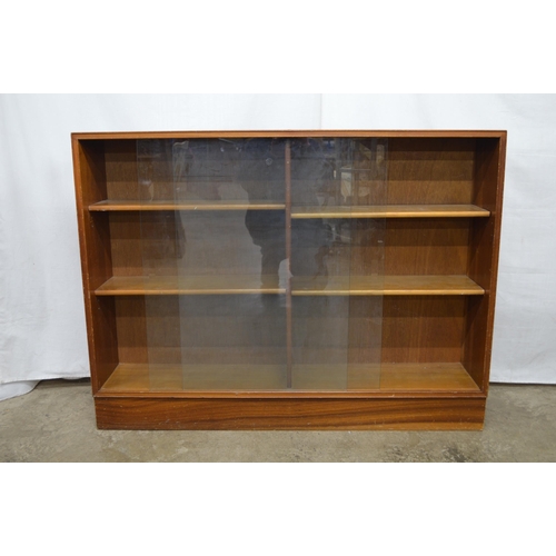 364 - Glazed teak bookcase, the two sliding doors opening to two divisions with four adjustable shelves, s... 