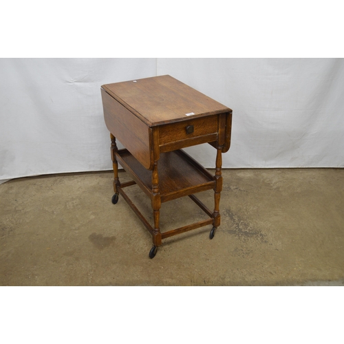 368 - Oak drop leaf tea trolley having a single drawer over a lower tier, standing on turned stretchered l... 