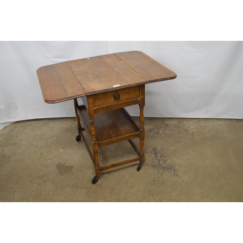 368 - Oak drop leaf tea trolley having a single drawer over a lower tier, standing on turned stretchered l... 