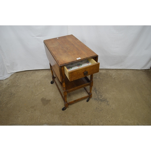 368 - Oak drop leaf tea trolley having a single drawer over a lower tier, standing on turned stretchered l... 