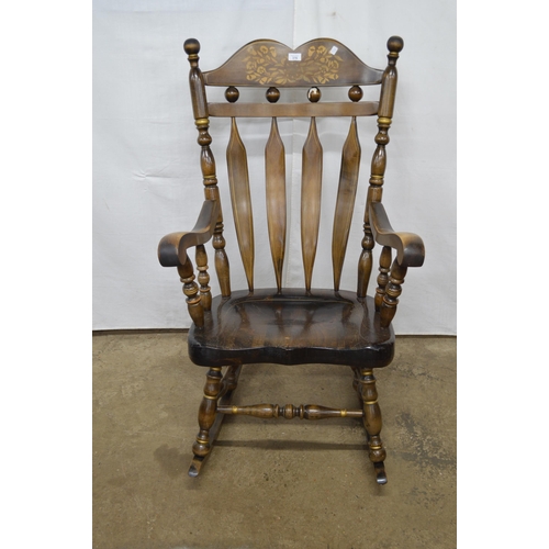 376 - Beech stained rocking chair having a gilt stencilled cresting rail, slat back and scrolled arms, sta... 