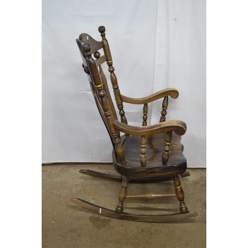 376 - Beech stained rocking chair having a gilt stencilled cresting rail, slat back and scrolled arms, sta... 