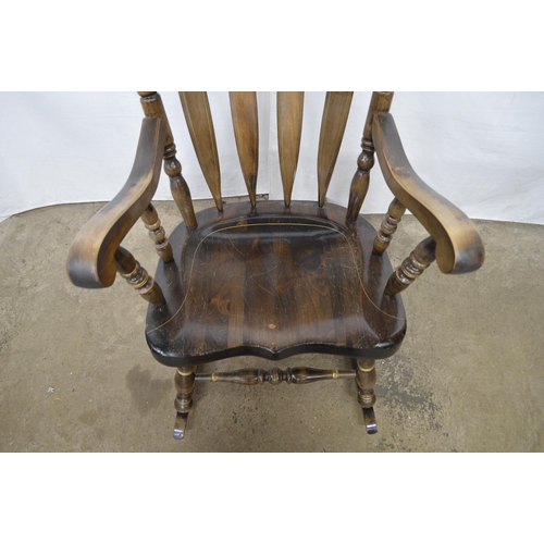 376 - Beech stained rocking chair having a gilt stencilled cresting rail, slat back and scrolled arms, sta... 