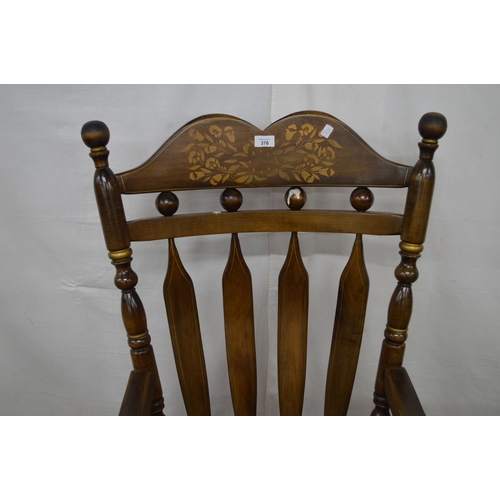 376 - Beech stained rocking chair having a gilt stencilled cresting rail, slat back and scrolled arms, sta... 