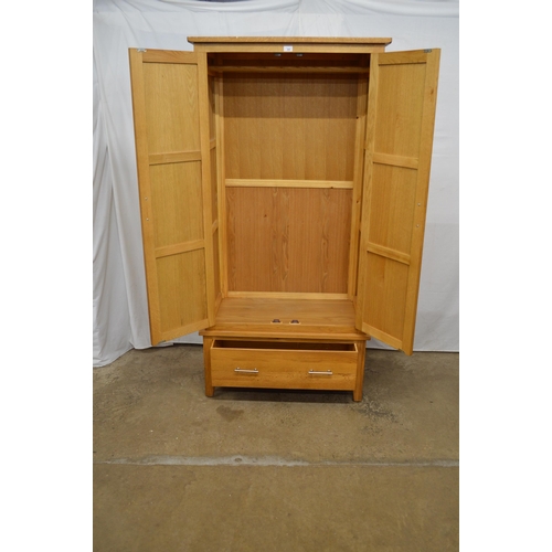 385 - Modern oak wardrobe, the upper section having panelled doors opening to a hanging rail, the lower se... 