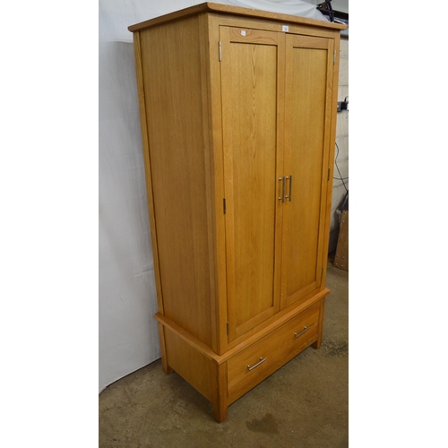 385 - Modern oak wardrobe, the upper section having panelled doors opening to a hanging rail, the lower se... 