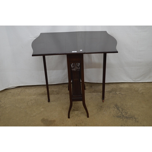 392 - Dark stained drop leaf occasional table, the shaped top over pierced sides, standing on splayed legs... 