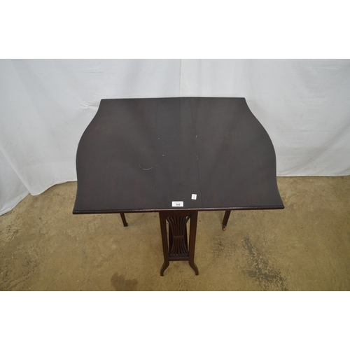 392 - Dark stained drop leaf occasional table, the shaped top over pierced sides, standing on splayed legs... 