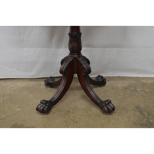 405 - Mahogany fold over tea table with a turned column on four carved splayed supports with paw feet and ... 