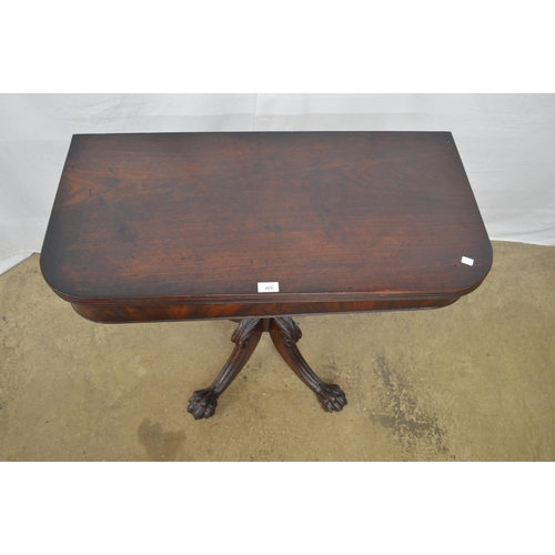 405 - Mahogany fold over tea table with a turned column on four carved splayed supports with paw feet and ... 