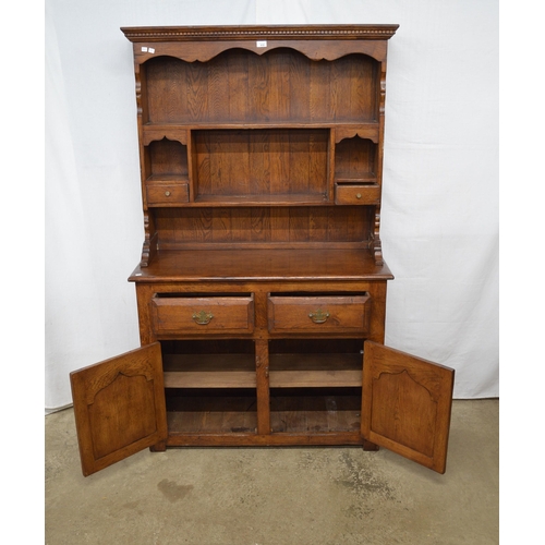 410 - Oak dresser, the top section having shaped frieze over two plate shelves with two small drawers, the... 