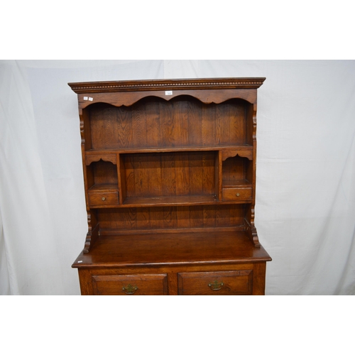 410 - Oak dresser, the top section having shaped frieze over two plate shelves with two small drawers, the... 