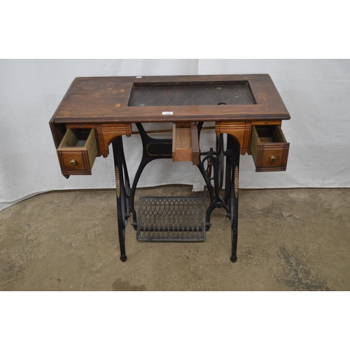 413 - Cast iron treadle sewing machine table having a wooden top with two drawers and drop flap - 88.5cm x... 