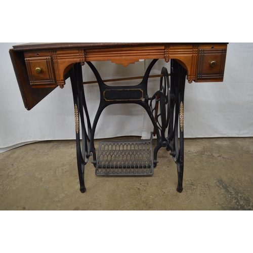 413 - Cast iron treadle sewing machine table having a wooden top with two drawers and drop flap - 88.5cm x... 