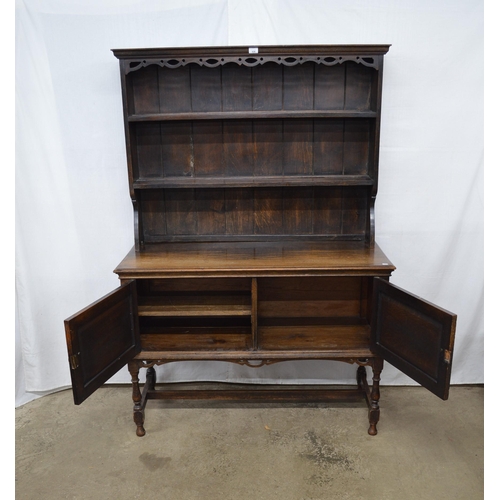 426 - Oak dresser, the top section having a pierced frieze over two plate shelves with a cupboard base, th... 