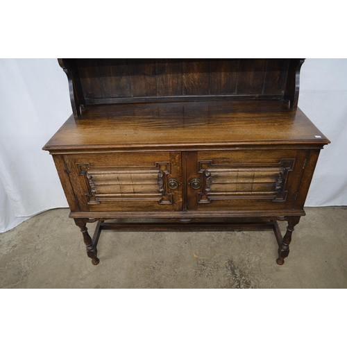 426 - Oak dresser, the top section having a pierced frieze over two plate shelves with a cupboard base, th... 