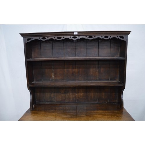 426 - Oak dresser, the top section having a pierced frieze over two plate shelves with a cupboard base, th... 