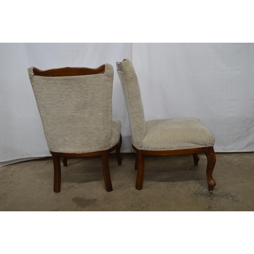 427 - Pair of carved upholstered bedroom chairs having padded button backs and seats, standing on carved c... 