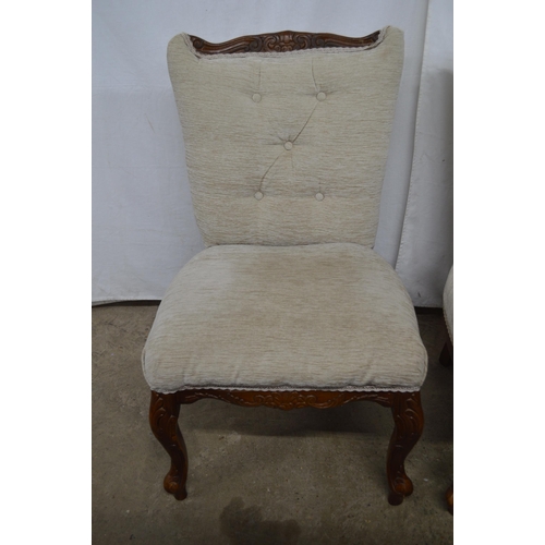 427 - Pair of carved upholstered bedroom chairs having padded button backs and seats, standing on carved c... 