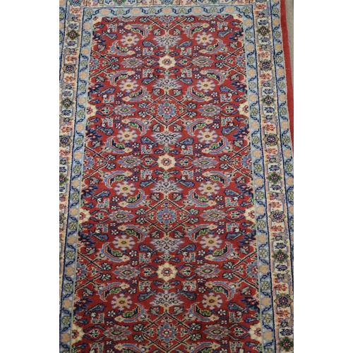 428 - Red and blue ground patterned rug having central repeating geometric pattern surrounded by patterned... 