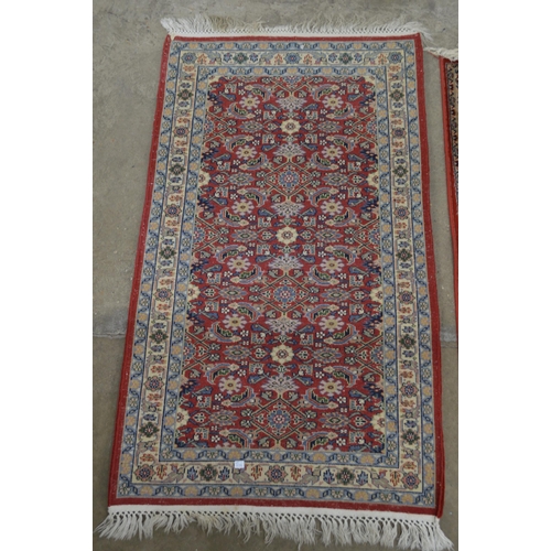 428 - Red and blue ground patterned rug having central repeating geometric pattern surrounded by patterned... 