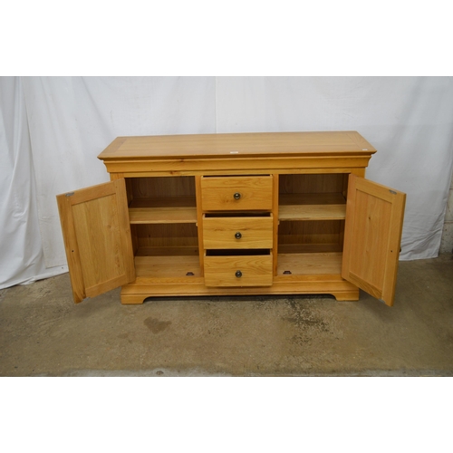 446 - Modern oak sideboard having three central drawers flanked by two cupboards, the panelled cupboard do... 