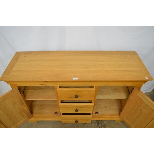 446 - Modern oak sideboard having three central drawers flanked by two cupboards, the panelled cupboard do... 