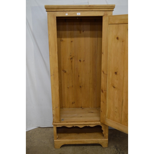 450 - Pine wardrobe, the panelled door opening to a hanging area and hooks with open storage space below, ... 