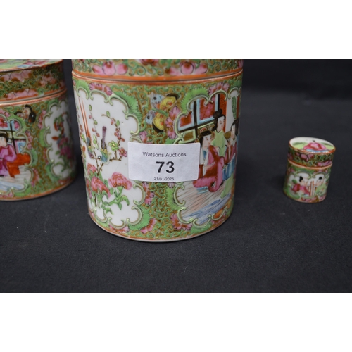 73 - Group of three Famille Rose pattern lidded jars of cylindrical form - tallest 12cm high