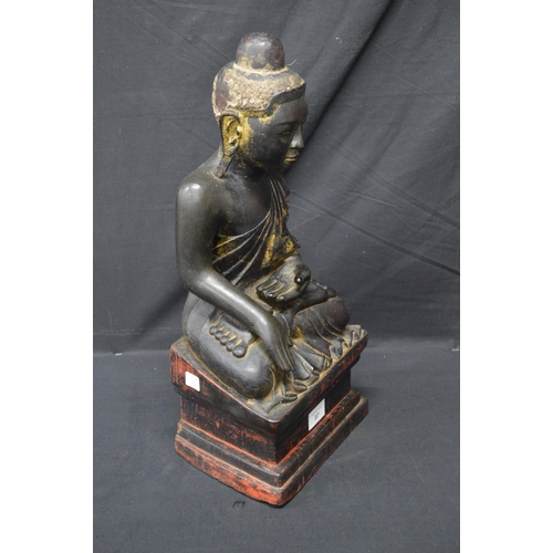 87 - Carved wooden figure of a seated Buddha - 47cm tall