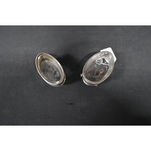 144 - Two Georgian silver salts of oval form with clear glass liners