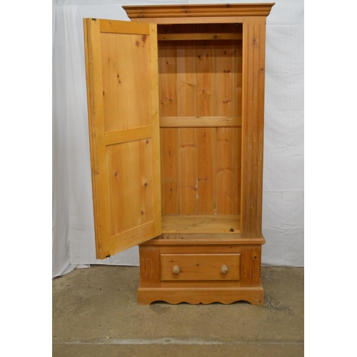 368 - Pine wardrobe, the panelled door opening to a hanging rail and space over a single drawer, standing ... 