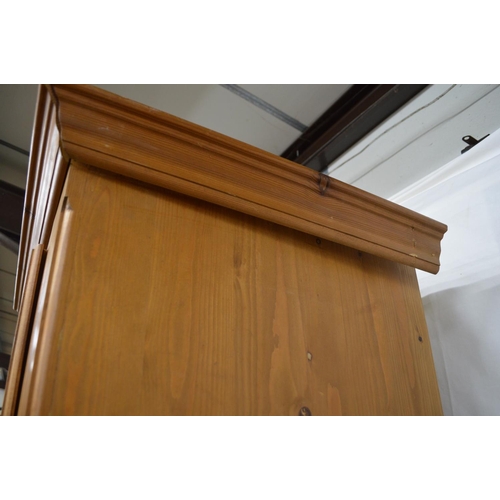 368 - Pine wardrobe, the panelled door opening to a hanging rail and space over a single drawer, standing ... 