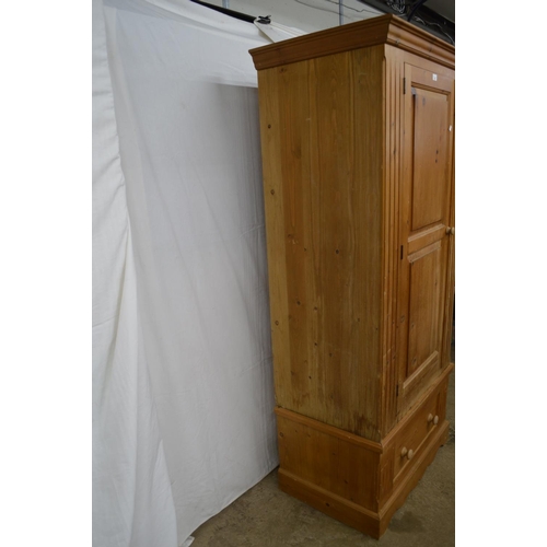 368 - Pine wardrobe, the panelled door opening to a hanging rail and space over a single drawer, standing ... 