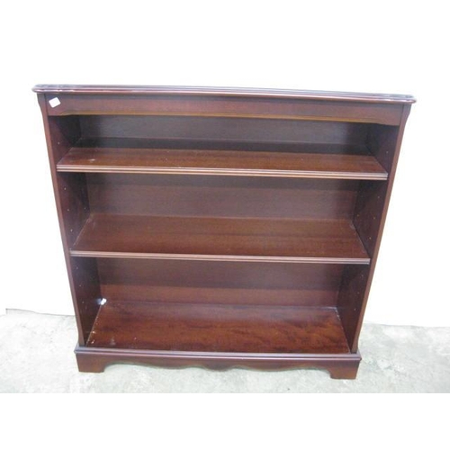 373 - Reproduction mahogany open bookshelves, the shaped top over two adjustable shelves, standing on a pl... 