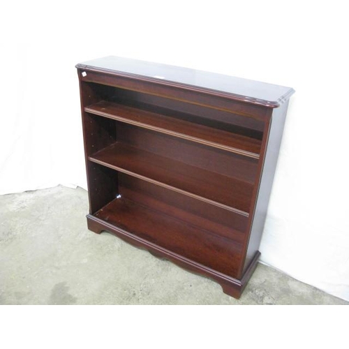 373 - Reproduction mahogany open bookshelves, the shaped top over two adjustable shelves, standing on a pl... 