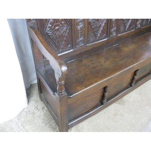 381 - 18th century carved oak box settle having five panel back carved with scrolled floral and lozenge de... 