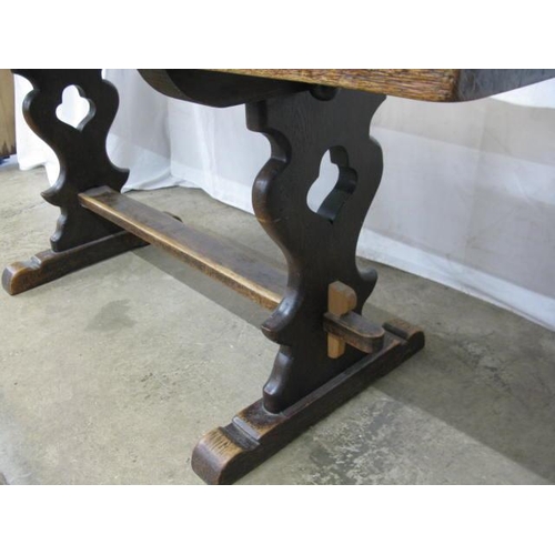 417 - Oak refectory table, the rectangular top standing on shaped pierced trestle legs with a hole and peg... 