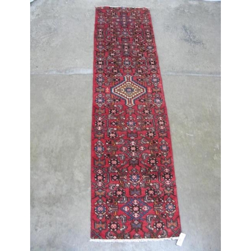 458 - Hamadan red ground patterned runner having a central lozenge design flanked by repeating geometric p... 