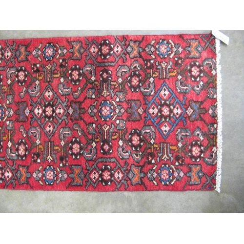 458 - Hamadan red ground patterned runner having a central lozenge design flanked by repeating geometric p... 