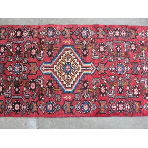 458 - Hamadan red ground patterned runner having a central lozenge design flanked by repeating geometric p... 