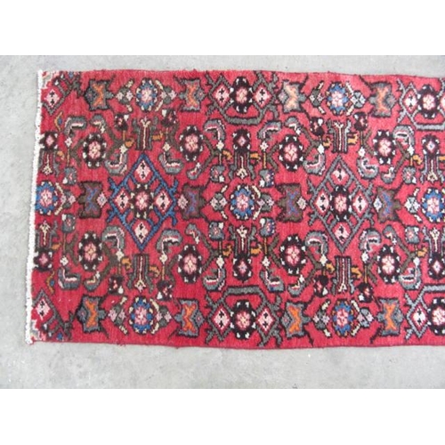 458 - Hamadan red ground patterned runner having a central lozenge design flanked by repeating geometric p... 