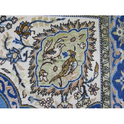 482 - Blue and cream ground patterned prayer rug having a central design with flowers in an urn flanked by... 