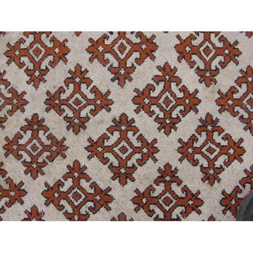 483 - Pair of Tunisian cream and orange ground patterned rugs both having a repeating geometric pattern an... 