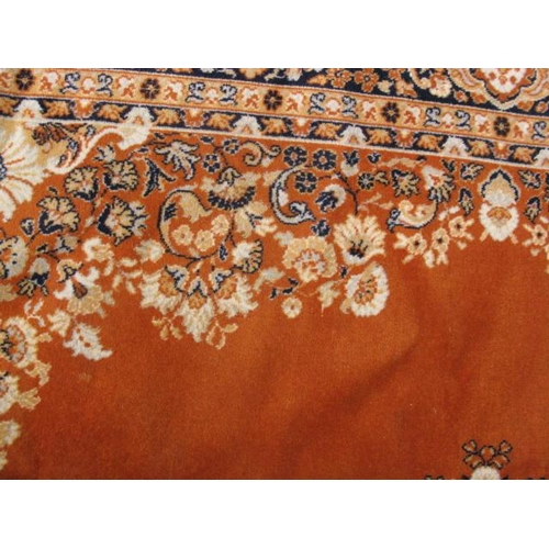 484 - Large Kamar orange ground patterned rug having a central stylized floral motif surrounded by five pa... 