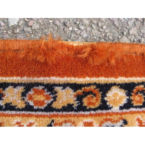 484 - Large Kamar orange ground patterned rug having a central stylized floral motif surrounded by five pa... 