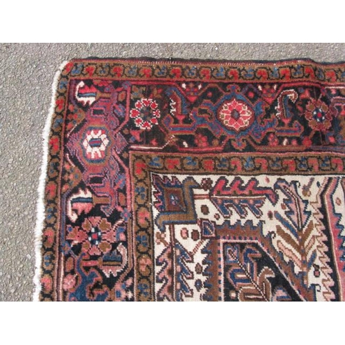 485 - Large red and cream ground patterned rug having a large central geometric motif surrounded by three ... 